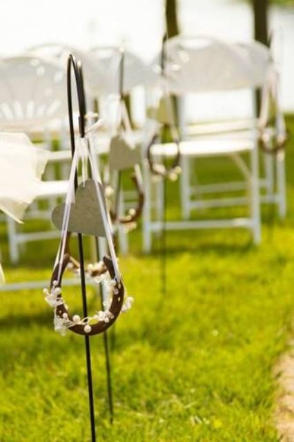 decorate your wedding aisle chairs with horseshoes with pearls and beads, a cardboard heart and ribbons