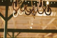 a rustic wedding chandelier of horseshoes and candles is a gorgeous idea for a rustic or cowboy wedding