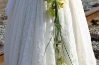 a unique wedding bouquet of a horseshoe, greenery and green orchids is a very cool idea for a bride