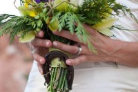 a colorful wedding bouquet accented with a single horseshoe is a creative idea for a rustic or cowboy bride
