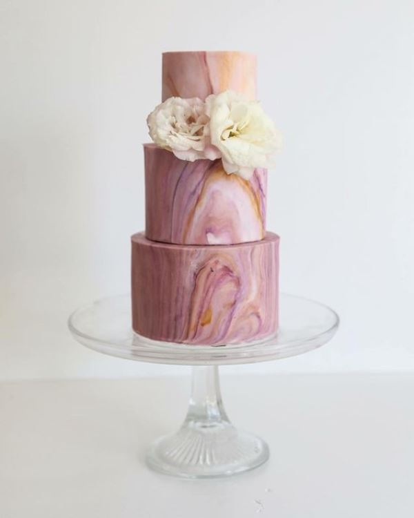 a beautiful pink marble wedding cake topped with fresh neutral blooms is a refined solution for a modern pastel wedding