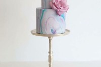a bright marble wedding cake decorated with a single pink flower is a pretty idea for a modern pastel wedding