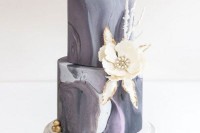 a grey marble wedding cake with a white sugar bloom with a brooch and some sugar branches for a winter wedding