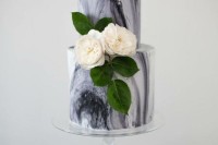 a grey marble wedding cake with white blooms and foliage is a classic idea for a spring or summer wedding