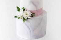 a white marble wedding cake with a pink ribbon and white blooms is a timeless dessert for an ethereal spring or summer wedding