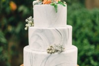a white marble wedding cake with neutral and bold blooms and berries is classics for a summer wedding