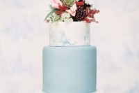 a lovely wedding cake with blue marble and a plain blue tier, bold blooms and greenery on top is chic and contrasting, great for a fall wedding