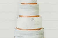 a four-tier white marble wedding cake decorated with copper ribbons is a stylish solution for a modern wedding