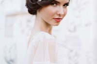 a sleek, twisted low updo with a bump and a rhinestone hairpiece is a refined idea for a vintage-inspired bride