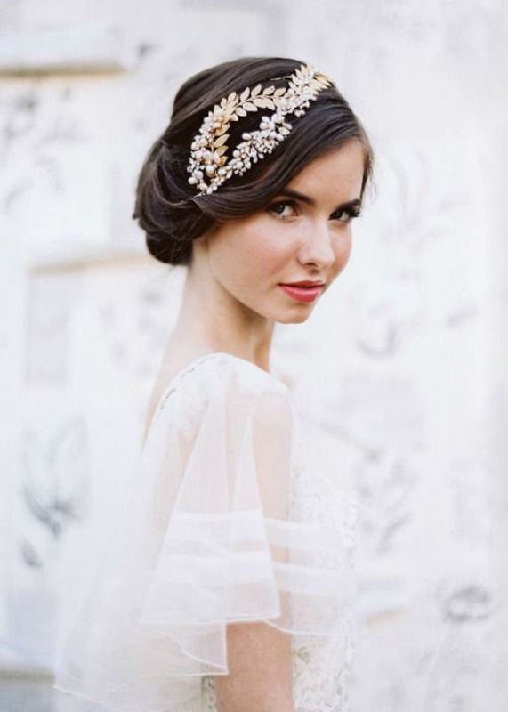 a sleek, twisted low updo with a bump and a rhinestone hairpiece is a refined idea for a vintage-inspired bride