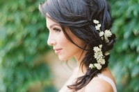 a messy side braid with some fresh blooms tucked in is a great relaxed wedding hairstyle to try