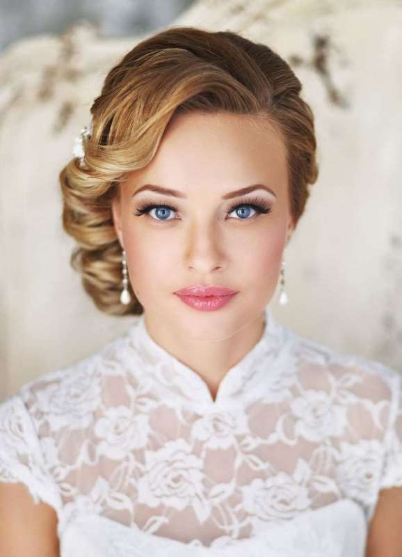 a refined and tight wavy side low updo with a voluminous top is a fit for a refined vintage bride