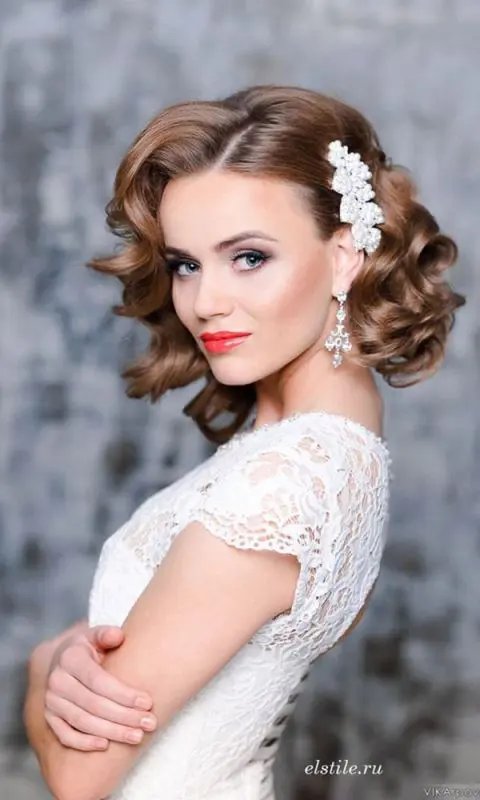 a vintage-inspired wavy hairstyle with a statement hairpiece is perfect for a refined vintage-inspired wedding