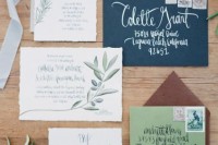 an earthy wedding invitation suite with a navy and a brown envelope, neutral invites with botanical prints and lovely calligraphy