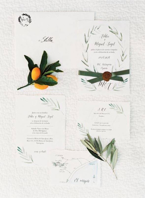 a lovely and ethereal wedding invitation suite with beautiful botanical patterns painted and green ribbon with a seal is a chic idea