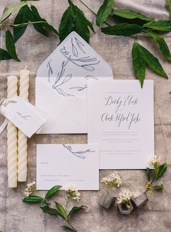 a subtle wedding invitation suite in white and blue, with botanical prints and calligraphy is a delicate idea