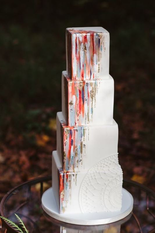 a catchy square wedding cake decorated with colorful touches and gold leaf looks bold and unusual