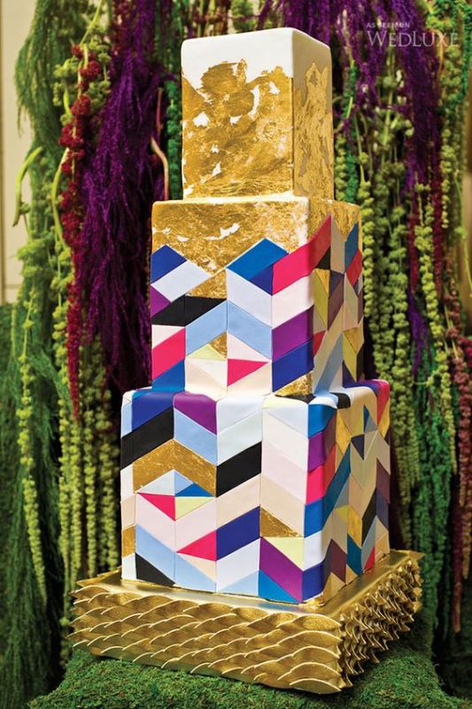 a colorful geometric wedding cake with lots of gold leaf on top looks bold, catchy and statement-like