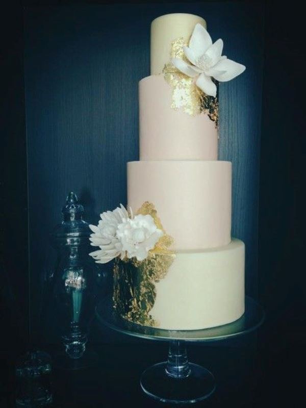 a pastel green and pink wedding cake decorated with gold leaf, with large sugar blooms is a chic idea for spring