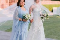Priyanka Chopra’s mother wearing a powder blue midi dress and a coverup plus matching shoes