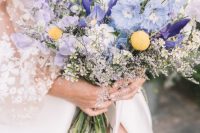 a beautiful and dreamy wedding bouquet with billy balls, blue irises, waxflower and dried blooms and grass is a chic idea to rock