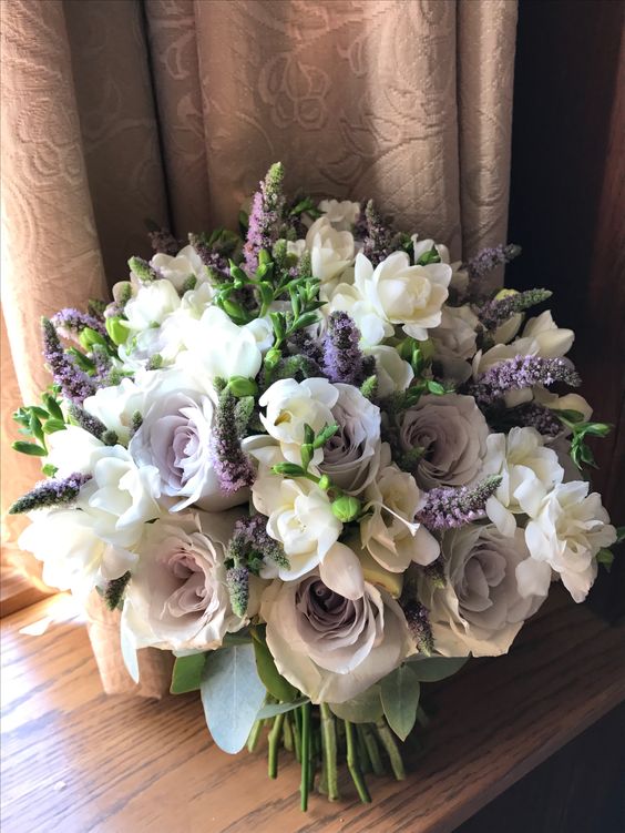 a beautiful fragrant hand tied bridal bouquet of Earl grey roses, white freesias, mentha and populous foliage