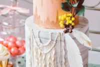 a bold boho wedding cake with a coral and grey marble tier, feathers, sugar macrame and berries and leaves