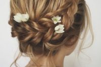 a braided updo with locks down, a dimensional bump and fresh blooms tucked into the braid