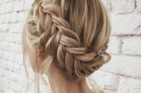 a braided updo with some locks down and some fresh blooms is a chic idea for a boho bride