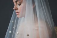 a bride wearing a star veil and a shiny strapless wedding dress for a celestial wedding