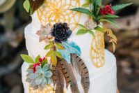 a bright boho wedding cake with painted dream catchers, sucuclents, bright blooms, succulents and feathers