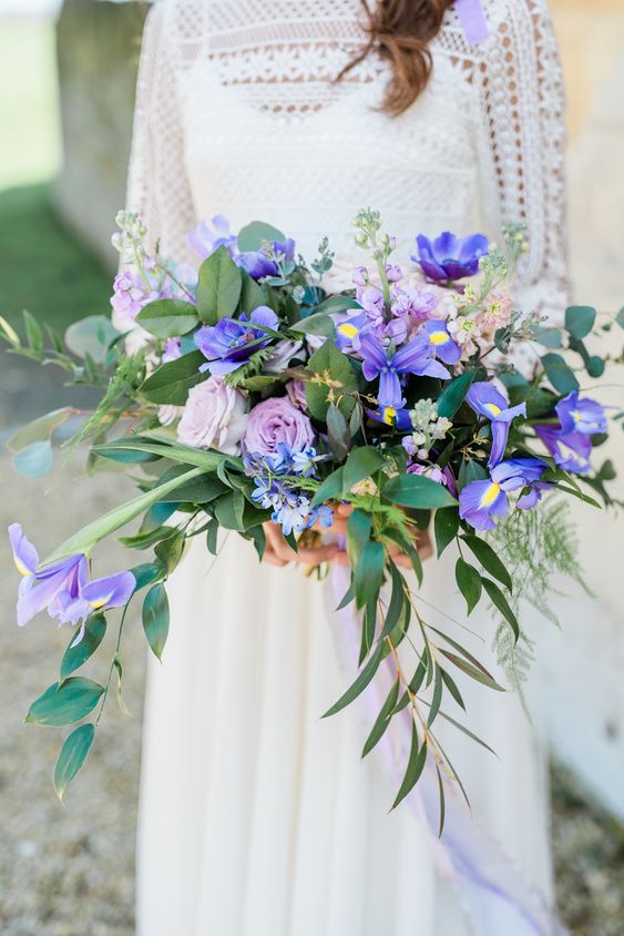 a cascading wedding bouquet with blue irises, lilac and blush blooms and greenery is a beautiful idea for a spring or summer bride