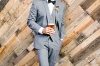 a chic groom’s look with a light grey three-piece suit, a black bow tie, a white button down and amber shoes