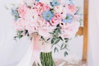 a chic light pink wedding bouquet of roses dotted with some serenity blue blooms and with long pink ribbons is a lovely solution