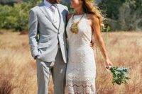 a chic summer groom look with a light grey suit, a wihite shirt and a tie, a man bun is boho and cool