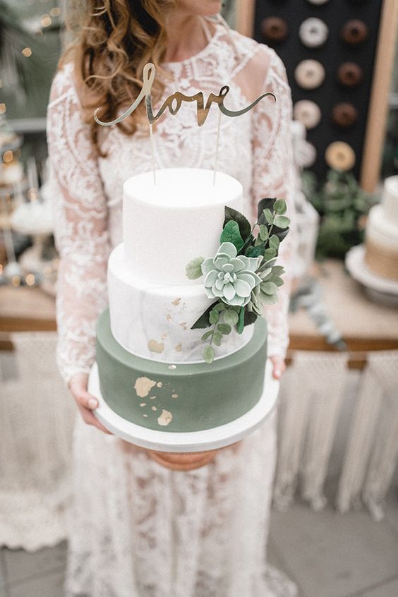 a chic wedding cake with a white, marble and green tier, gold leaf, greenery and a pale succulent is very trendy