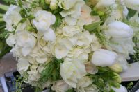 a chic white wedding bouquet of freesias, tulips and hydrangeas plus greenery is a lovely idea for a neutral spring wedding