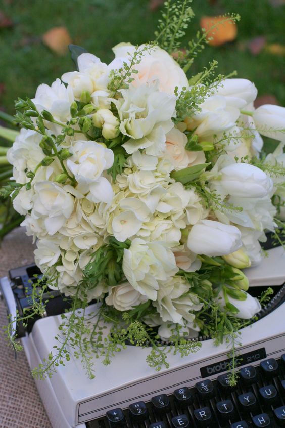 a chic white wedding bouquet of freesias, tulips and hydrangeas plus greenery is a lovely idea for a neutral spring wedding