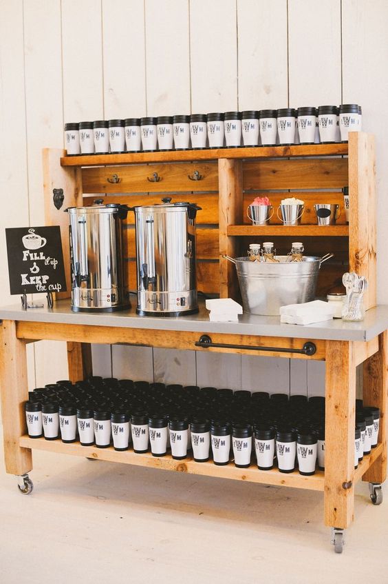 a coffee station with personalized travel tumblers that will double as wedding favors