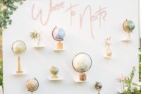 a cool wedding backdrop or photo booth backdrop with various globes and blooms and greenery around