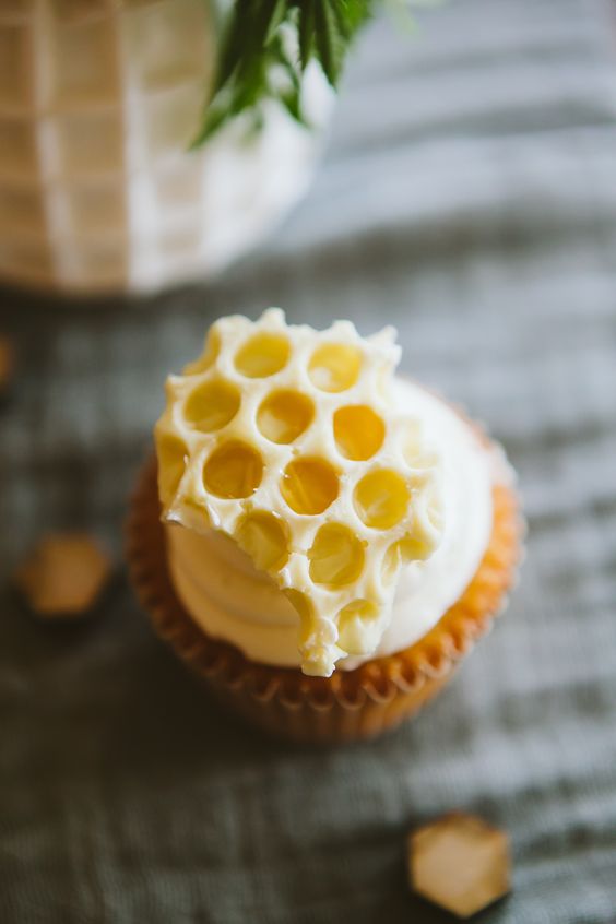 a cupcake topped with frosting and honeycombs is a gorgeous dessert for a wedding, pair it up with a honeycomb wedding cake