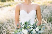 a delicate lush and dimensional wedding bouquet of white and serenity blue blooms, eucalyptus and thistles is a very chic and cool idea