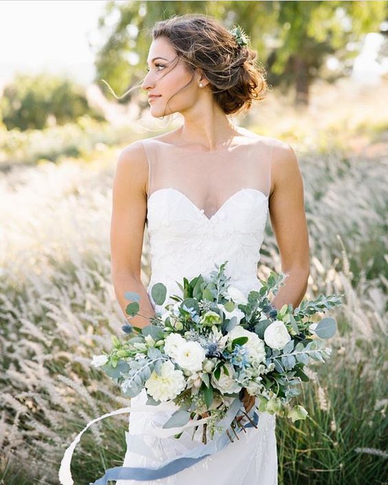 a delicate lush and dimensional wedding bouquet of white and serenity blue blooms, eucalyptus and thistles is a very chic and cool idea