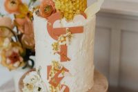 a gorgeous white wedding cake with sugar letters, topped with honeycombs, blooms and gold touches is amazing for a honey-themed wedding