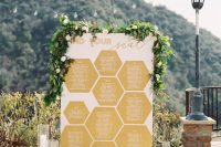 a honeycomb wedding seating chart with gold honeycombs and greenery and blooms is a stylish idea not only for a honey-themed wedding
