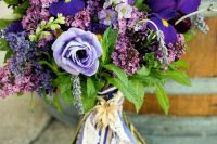 a lovely wedding bouquet of blue irises, lilac and purple blooms, lilac itself and some long ribbons is a cool idea
