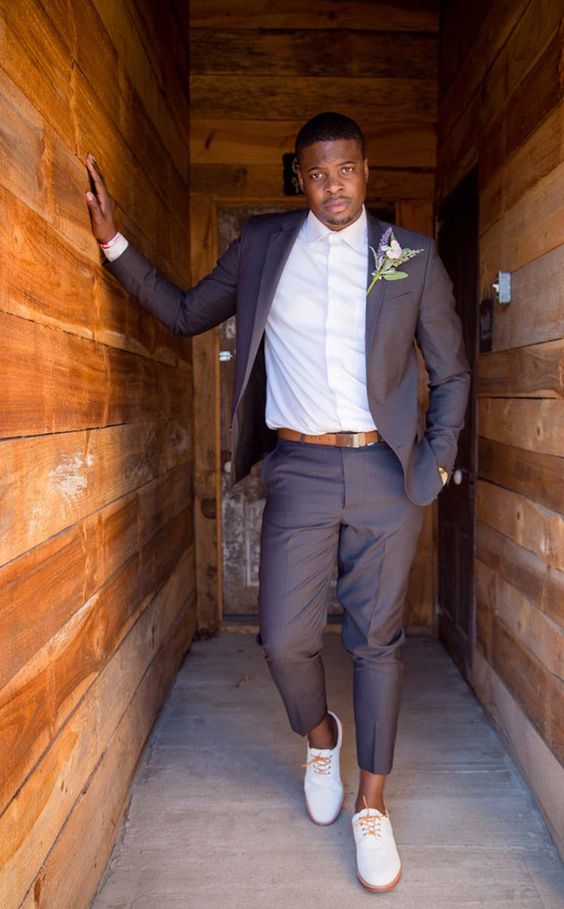 a modern barn groom's look with a chocolate brown suit, a white button down, creamy shoes and amber touches