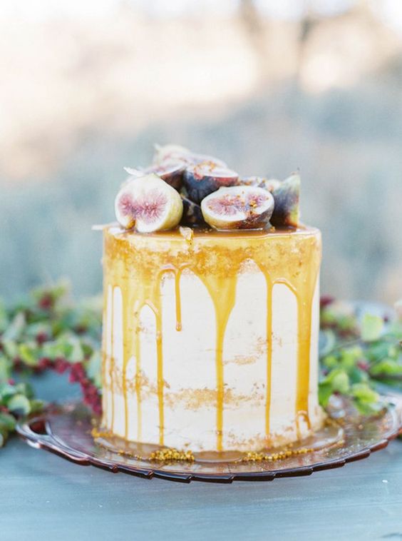 a naked wedding cake topped with cut figs and honey is a lovely idea for a fall boho wedding
