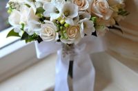 a neutral wedding bouquet of white freesia, blush roses, berries and foliage is a cool idea for an elegant wedding