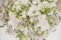 a neutral wedding bouquet of white freesias, waxflower and greenery is a cool idea for a spring or summer wedding